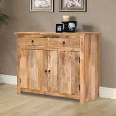 a wooden cabinet with two pictures on the wall