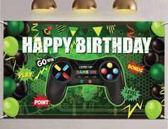 a video game birthday banner hanging on the wall with balloons and confetti around it