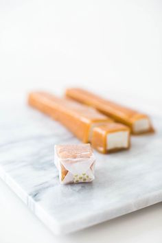 three pieces of food sitting on top of a marble cutting board