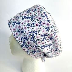 a white mannequin head wearing a floral print scrub hat