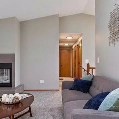 a living room filled with furniture and a flat screen tv mounted on a wall above a fire place