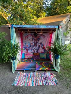 an outdoor area with various colored rugs and decorations