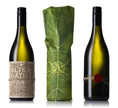 three bottles of wine are shown next to a green bag with a leaf on it