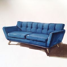 a blue couch sitting on top of a hard wood floor next to a white wall