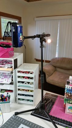 a camera is sitting on a tripod next to some crafting supplies and other items