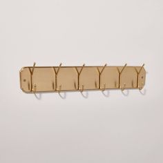 a wall mounted coat rack with five hooks