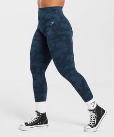 a woman in black and blue camouflage print leggings with her hands on her hips