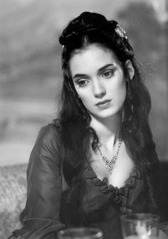 an old black and white photo of a woman with long hair wearing a tiara