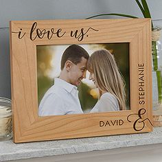 a wooden photo frame with the words i love us and a couple holding each other