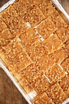 a pan filled with squares of food on top of a wooden table