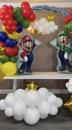 mario birthday party decorations with balloons and streamers on the shelf in front of them