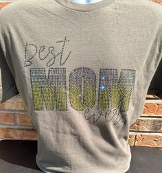 Best Mom Ever Rhinestone Bling T-shirt. Made to order by me with Quality Rhinestones (Cosmic Nite, Olive, and Olive AB). Military Green Tee. Shirt Information:  4.5 oz., 100% preshrunk ringspun cotton jersey. Modern Fit. Adult Unisex sizes up to 5x. Due to the nature of custom garments, we do not accept returns or exchanges unless there is a product defect. Please contact me with questions about sizing. Graphic Tee T-shirt With Rhinestones, Short Sleeve, Rhinestone Cotton Crew Neck T-shirt, Cotton Short Sleeve T-shirt With Rhinestones, Cotton T-shirt With Rhinestones And Short Sleeves, Cotton T-shirt With Rhinestones Short Sleeve, Green Tee, Bling Shirts, Modern Fit, Best Mom