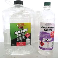 two bottles of methylated spirits sitting on a table