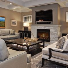 a living room filled with furniture and a flat screen tv mounted on the wall above a fireplace