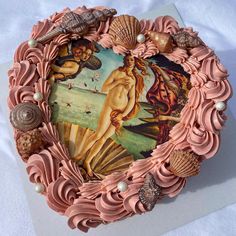 there is a pink cake decorated with shells and mermaids on the bottom, along with other decorations