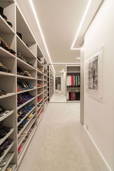 an empty walk in closet with shoes on shelves