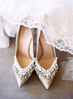 the bride's wedding shoes are adorned with pearls and sequins, along with lace