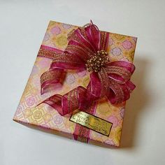 a pink and gold box with a bow on it