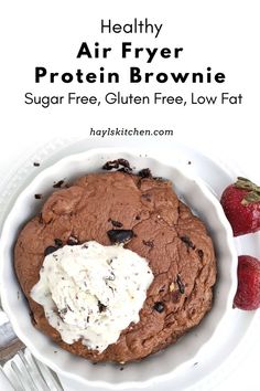 a white bowl filled with chocolate cookies and whipped cream next to strawberries on a plate