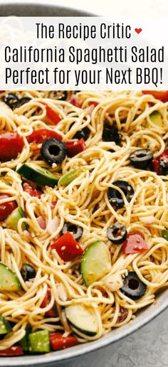 a bowl filled with spaghetti and veggies on top of a table