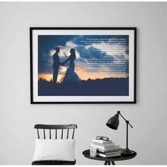 a couple holding hands under a cloudy sky with the sun setting in the background framed print