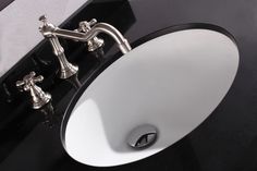 a bathroom sink with chrome faucet and black counter top