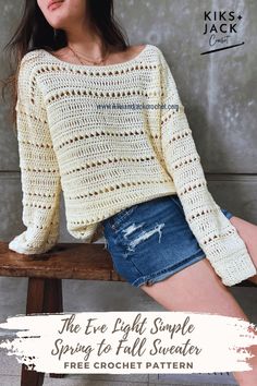 a woman sitting on top of a wooden bench wearing a white sweater and denim shorts