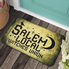 a door mat that says salem local witches union on the floor next to a potted plant