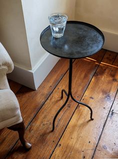 a glass sitting on top of a table next to a chair