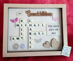 a wooden frame with scrabbles and butterflies in it