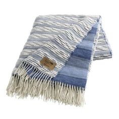 a blue and white striped blanket with fringes on the bottom, in front of a white background