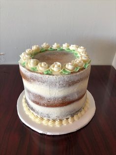 a cake sitting on top of a wooden table covered in frosting and icing