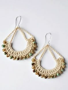 a pair of earrings with beads hanging from the end of each earring, on a white background