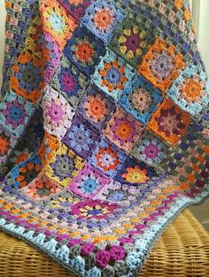 a colorful crocheted blanket is sitting on a chair