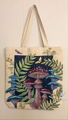 a tote bag hanging on the wall with mushrooms and leaves around it in front of a white background