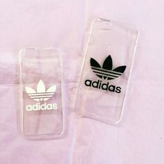 two adidas phone cases sitting next to each other on a pink sheet covered bed