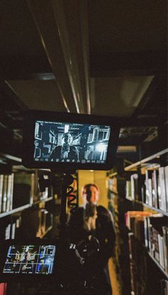 a camera is set up to take pictures of people in a library with bookshelves