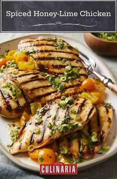 grilled chicken on a white plate with tomatoes and green onions next to it is the title, spiced honey - lime chicken