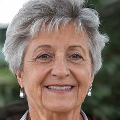 an older woman with gray hair smiling at the camera