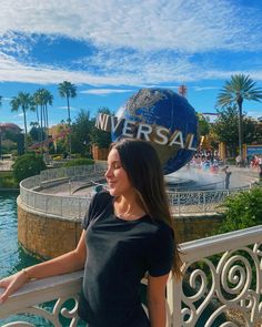 a woman standing on a balcony next to the universal studios sign and water park area