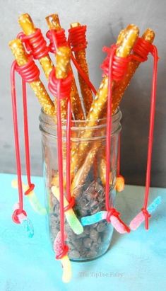 some candy sticks are in a glass jar