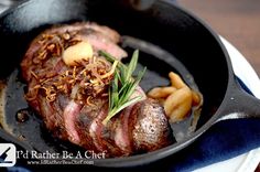 a steak in a skillet with french fries