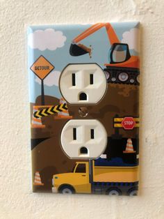 an electrical outlet cover with construction vehicles on it