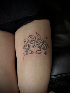 a woman's thigh with a tattoo design on her left leg, and a snake in the middle