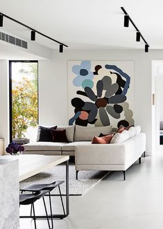 a living room filled with furniture and a painting on the wall