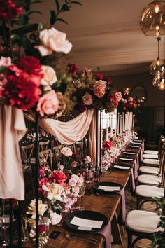 a long table is set up with flowers and place settings for an elegant wedding reception