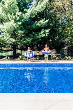 two boys are playing in the pool with their boogie boards and swimming floatie toys