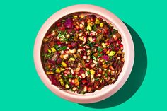 a bowl filled with lots of food on top of a green table