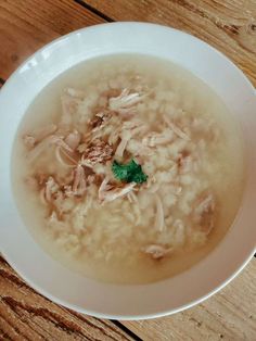 a white bowl filled with soup on top of a wooden table