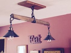 three light fixtures hanging from the ceiling in a room with pink walls and framed pictures